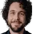 Portrait of Chris M., a brown-haired man in his mid-30s, smiling confidently