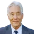 Portrait of Dan S., an older gray-haired Asian man, smiling with satisfaction.